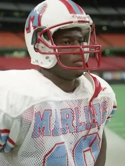 Vince Young wearing a football helmet and a Madison Marlins mesh jersey during a game.