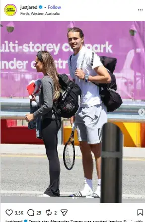 Alexander Zverev holding a tennis racquet and carrying backpacks alongside Sophia Thomalla walking in athletic attire in Perth