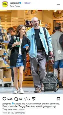 Natalie Portman and her boyfriend Tanguy Destable walking together through a Paris shop with rolling luggage.