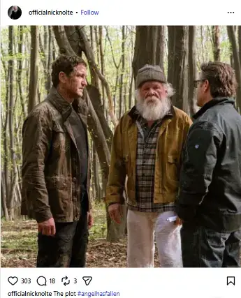 Nick Nolte with a full white beard and beanie standing in the woods between Gerard Butler and a crew member on the set of Angel Has Fallen.