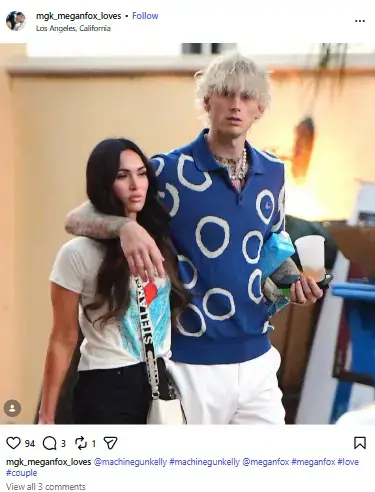 Machine Gun Kelly with blonde hair wrapping his arm around Megan Fox as they walk together outdoors in casual streetwear.