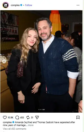 Amanda Seyfried in a black blazer smiling next to Thomas Sadoski in a navy knit cardigan at an evening event.
