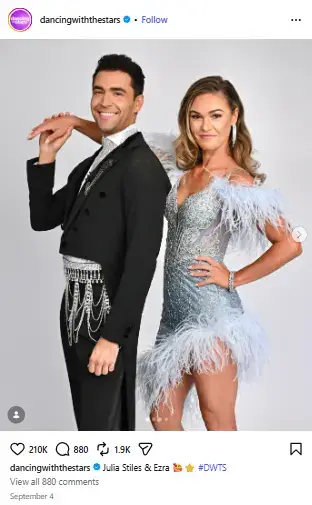 Julia Stiles in a sparkling feathered gown posing alongside partner Ezra Sosa in an embellished black tuxedo for Dancing with the Stars.