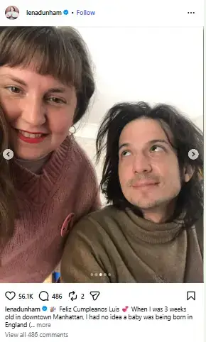 Lena Dunham smiling close to the camera in a pink knit sweater next to her husband Luis Felber looking upward.