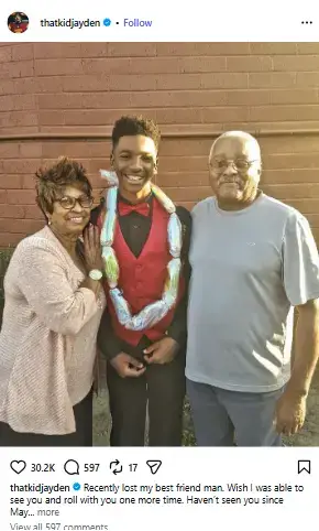 Young Jayden Daniels smiling in a red vest and candy lei while standing between his loving grandparents outdoors.