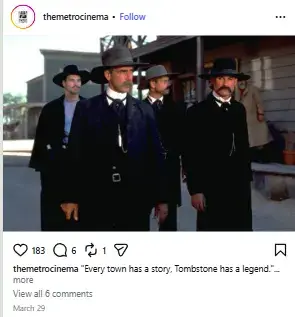 Sam Elliott and cast walking side by side in dark long coats and Western hats down a dusty street in Tombstone