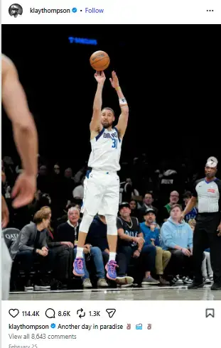 Klay Thompson rising mid-air in a white Dallas Mavericks uniform to release a high-arcing jump shot during an NBA game.