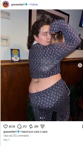 Grace Reiter posing from behind in printed pajama pants and top while looking over her shoulder with an arm raised.