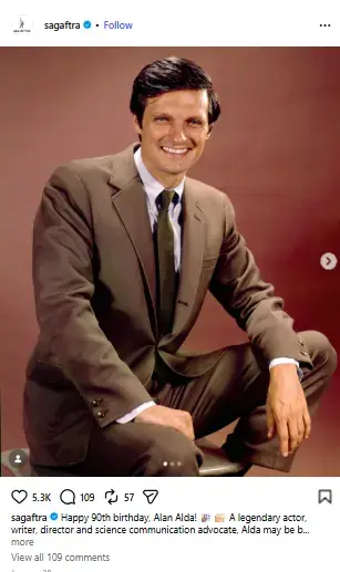 A smiling young Alan Alda posing in a brown suit, dress shirt, and tie while seated against a warm studio backdrop.