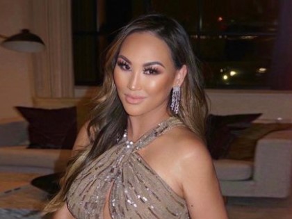 Dorothy Wang wearing the halter neck sparkling gown and looking at the camera.