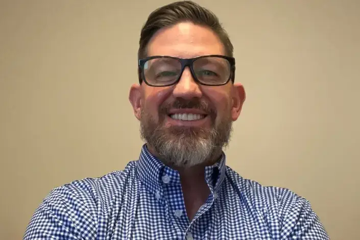 Peter Nottoli with a full beard and glasses.