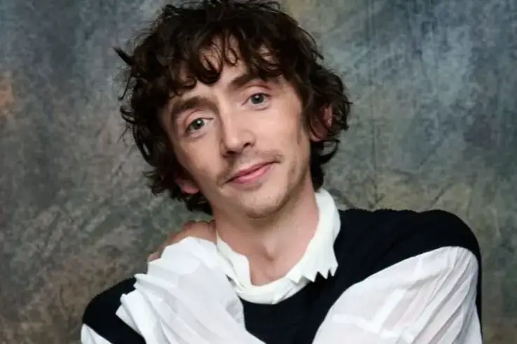 Samuel Blenkin with curly brown hair.