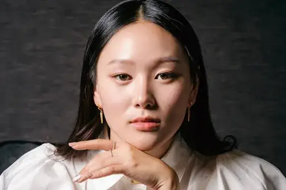 A close-up portrait of actress Yerin Ha wearing a red outfit at a premiere event.