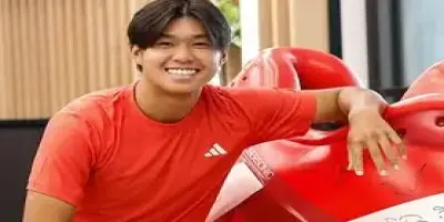 A photo of a smiling Learner Tien wearing a red Adidas shirt