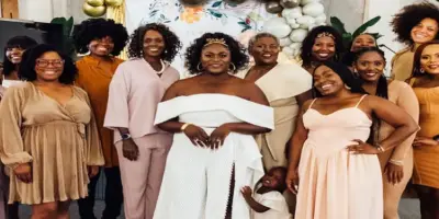 Danielle Brooks in a white outfit, with her Sisterhood and daughter.