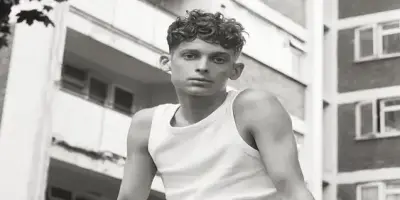 A black-and-white headshot of Joe Freeman with curly hair.