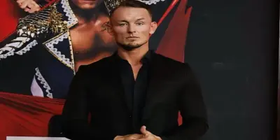 Professional wrestler Ludwig Kaiser poses for a photo in a black suit.