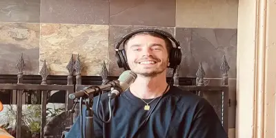 David Boyd, wearing headphones and a black t-shirt, smiles at the camera.